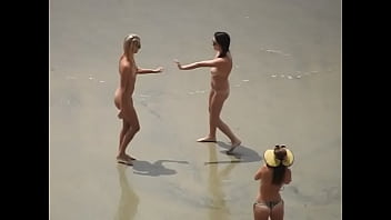 Topless photographer takes pictures of nude friends at beach