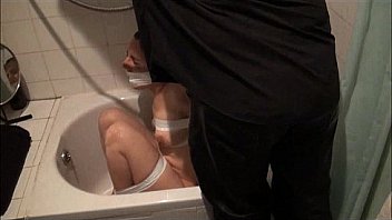 Bath bondage of submissive Honesty Cabellero in gagged restraints and wet toilet