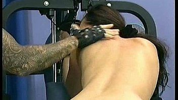 Hot brunette girl tied to a fitness machine got metal clamps on her pussy and is spanked